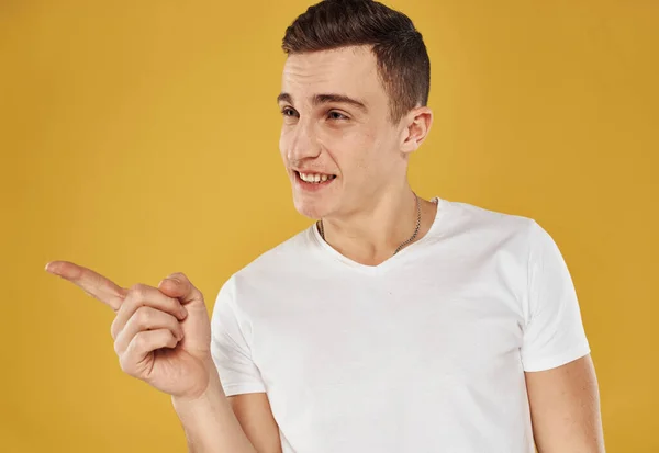 Portrait of a handsome guy in a white t-shirt on a yellow background cropped view — Stock Photo, Image