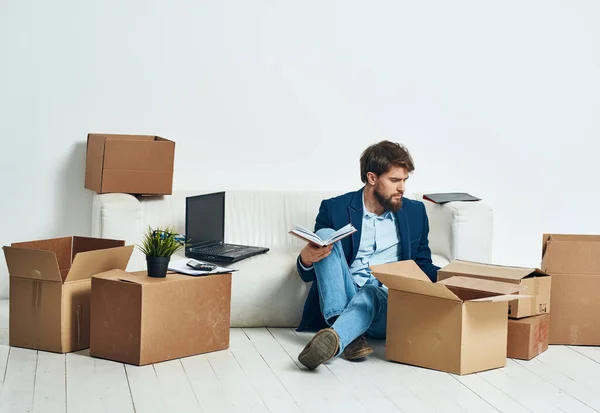 Ein Mann sitzt auf dem Boden einer Kiste mit Dingen, die Büro auspacken offiziellen — Stockfoto