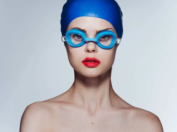 Donna in occhiali blu cuffia nuoto spalle nude sfondo chiaro — Foto Stock
