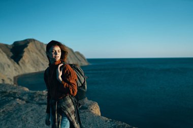 Sırt çantalı bir kadın. Dağlarda yürüyor. Temiz hava.