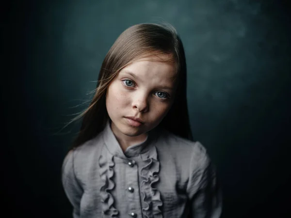 Vintage portrait of a girl in a dress on a dark background beautiful face cropped view — Stock Photo, Image
