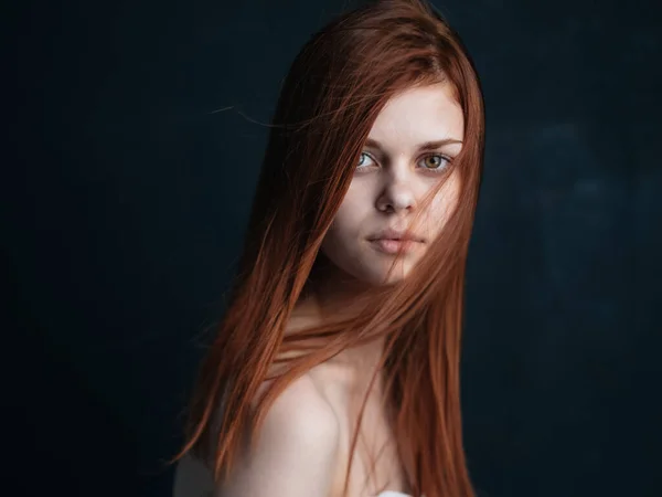 Közelkép kivágott kilátás egy nő vörös haj néz előre a fekete háttér — Stock Fotó