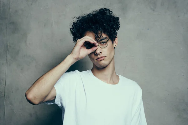 Guy in white t-shirt gesturing with hand curly hair emotions Studio — Stock Photo, Image