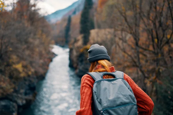 Mujer con mochila admira el río en las montañas naturaleza viaje — Foto de Stock