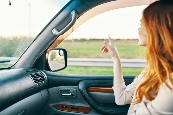 Mujer feliz en suéter de conducción en el asiento delantero de un coche limpio modelo de diseño de interiores — Foto de Stock