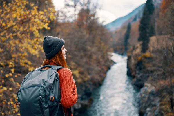 Mulher caminhante com mochila em suas costas perto do rio da montanha na natureza — Fotografia de Stock