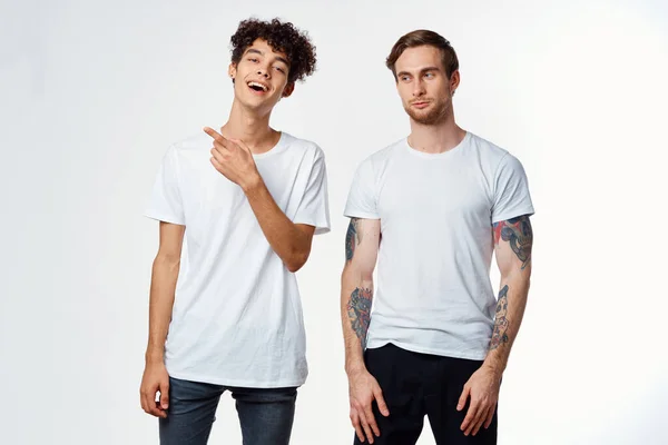 Dos amigos alegres en camisetas emociones estilo de vida fondo claro — Foto de Stock