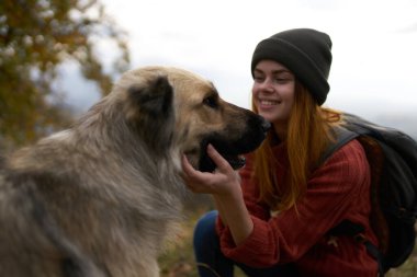 Bayan turistler dışarıda köpekle oynuyorlar. Arkadaşlık neşesiyle seyahat ediyorlar.