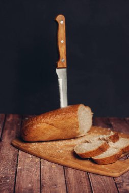 Taze gevrek somun, tahta bıçak, ahşap masa unu ürünü.