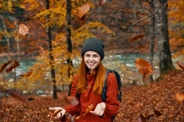 Veselá žena cestuje v podzimním lese v přírodě v blízkosti řeky a vysoké stromy v pozadí — Stock fotografie