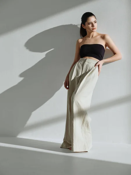 Linda morena de longitud completa ropa de moda apoyada contra la pared — Foto de Stock