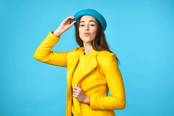 Bela mulher em chapéu azul e casaco amarelo no fundo isolado vista cortada — Fotografia de Stock