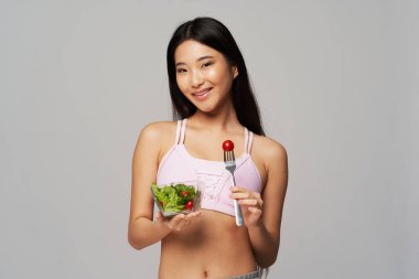 Güzel Asyalı kadın ince tabaklı ve salatalı sağlıklı yemek diyeti.