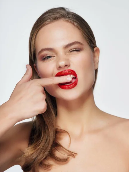 Ładna kobieta nagie ramiona czerwone usta palec w pobliżu ust — Zdjęcie stockowe
