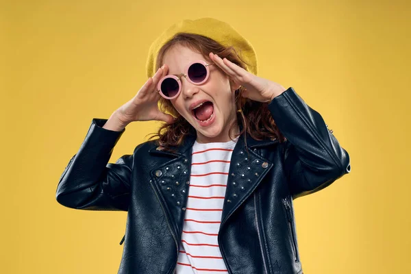 Niña alegre en gafas de sol y sombrero estilo de vida estudio fondo amarillo moda — Foto de Stock