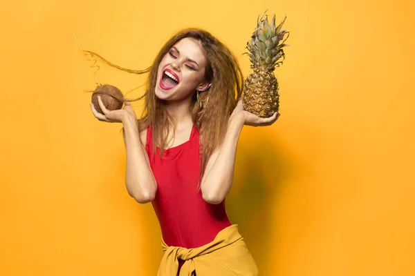 Kvinna med ananas och kokos cocktail exotiska frukter sommar livsstil gul bakgrund — Stockfoto