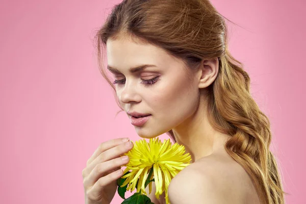 Portrét ženy se žlutými květy na růžovém pozadí make-up na tváři — Stock fotografie