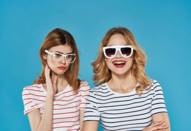 Çizgili tişörtlü iki kadın duygularıyla neşe iletişimi arkadaşlık yaşam tarzı mavi arka plan