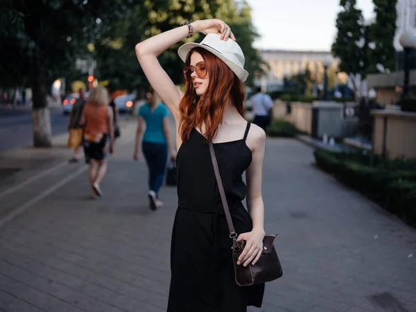 Mujer de moda en vestido negro y bolso de gafas en el Parque natural del hombro — Foto de Stock