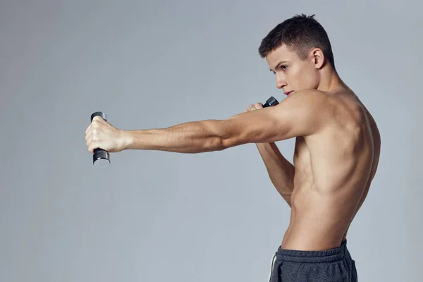 Ragazzo sportivo con un pompato-up corpo manubri nelle sue mani allenamento fitness — Foto Stock