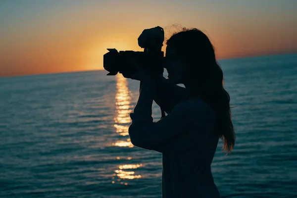 해 가 지는 곳에 카메라를 든 여성 사진 작가 — 스톡 사진
