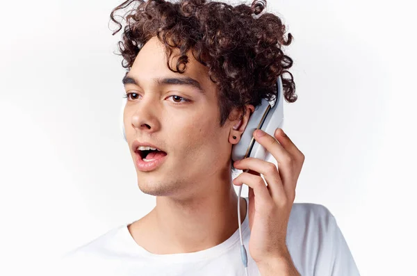 Chico de pelo rizado en los auriculares escuchando música recortado ver emoción — Foto de Stock