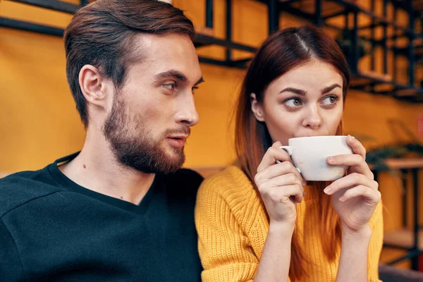 Süveter giyen bir adam ve bir fincan kahve içen bir kadının portresi. — Stok fotoğraf