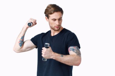 Beyaz arka plan görünümlü siyah tişörtlü bir sporcu.