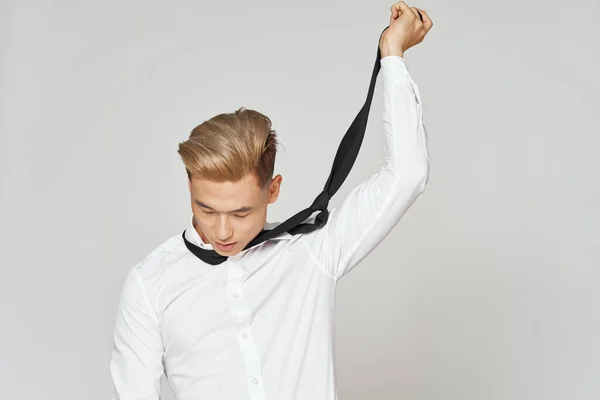 Een man in een wit shirt trekt een das om zijn nek problemen op het werk stress ontslag — Stockfoto