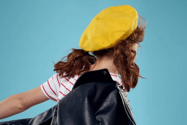 Fashionabla flicka i en svart jacka med en gul biljett randig T-shirt blå bakgrund — Stockfoto
