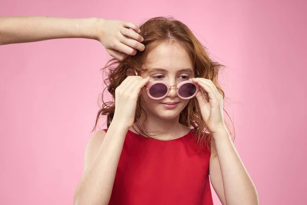 Chica con pelo rizado gafas redondas oscuras divertido vestido rojo fondo rosa — Foto de Stock