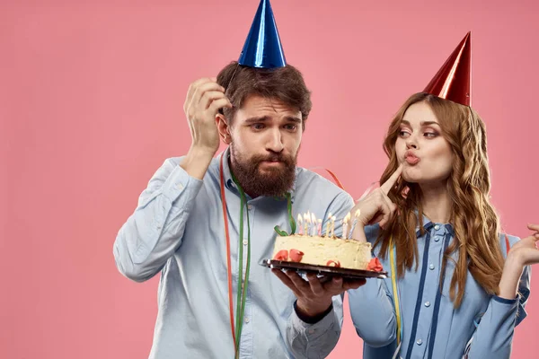 Party man och kvinna med tårta på rosa bakgrund företags födelsedag — Stockfoto