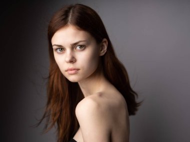 Gri arka planda kızıl saçlı kadın portresinin yan görüntüsü. Güzel yüz.