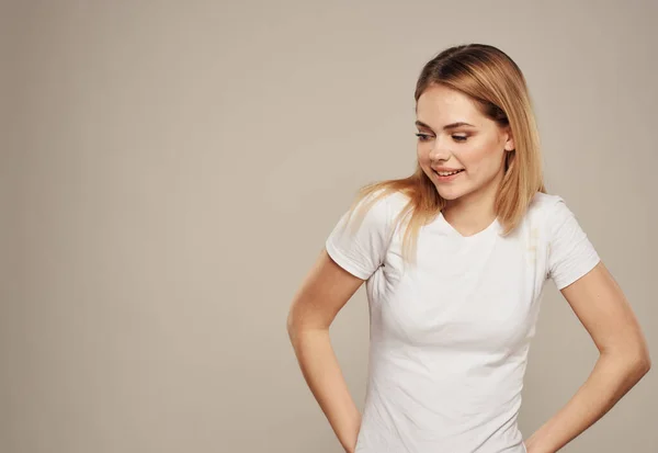 Bella donna in una t-shirt bianca su uno sfondo grigio gesti Copy Space — Foto Stock