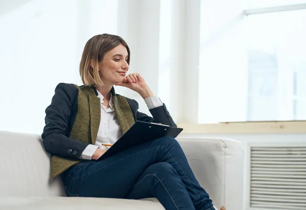 Zakelijke vrouw in pak met documenten zittend op de bank binnen — Stockfoto