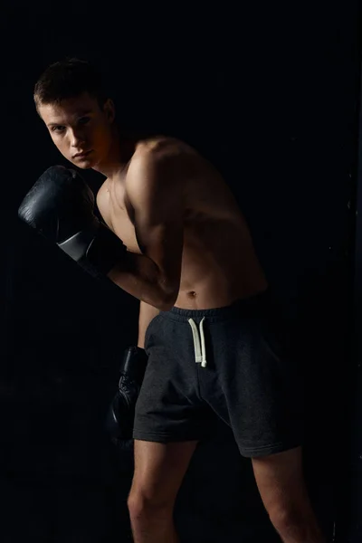 검은 색 바탕에 권투 장갑을 끼고 있는 보디빌더 — 스톡 사진