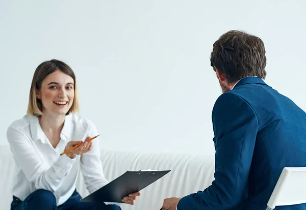 Un uomo in giacca e cravatta si siede su una sedia e una donna su un divano psicologo comunicare — Foto Stock