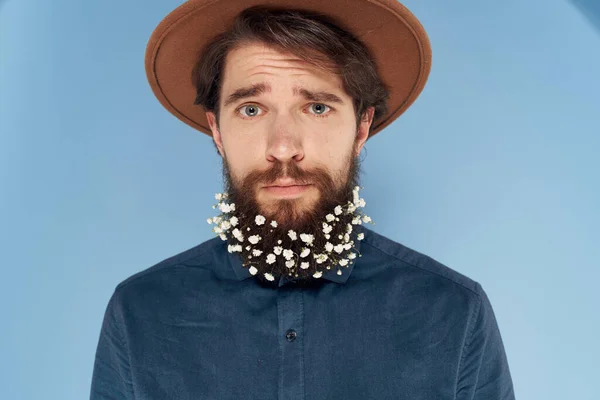 Mężczyzna z kwiatami w brodzie atrakcyjny wygląd koszuli niebieski tło — Zdjęcie stockowe