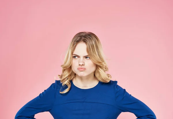 Nette Blondine blaues Kleid Lifestyle Emotionen Missfallen rosa Hintergrund — Stockfoto