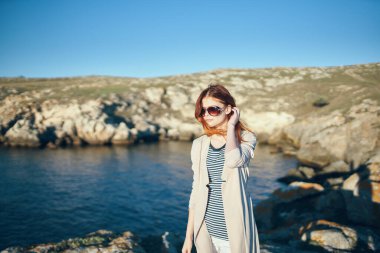 Kadın dağlarda gezer doğada ve yüzünde gözlüklerle Mavi nehir deniz modeli
