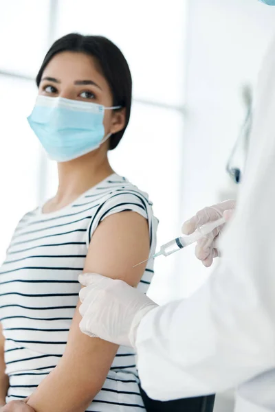 Médecin masculin en manteau blanc fait environ tourné sur la vaccination des patientes — Photo