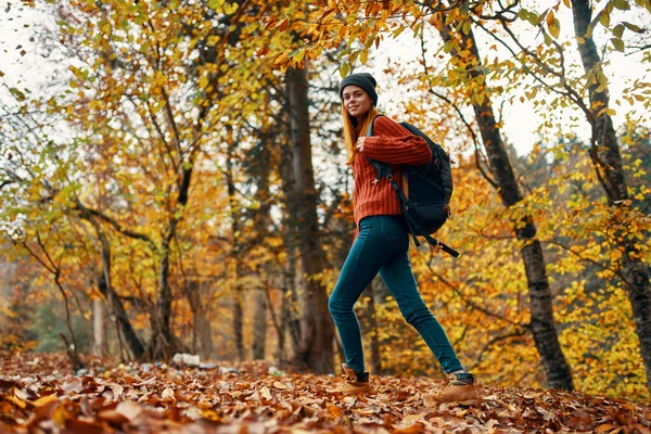 Красивая женщина с рюкзаком в парке на природном ландшафте упал листья вид снизу — стоковое фото