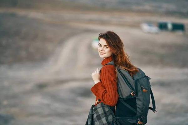 Sırt çantalı güzel bir kadın dağlarda dinleniyor. Arka planda turizm modeli. — Stok fotoğraf