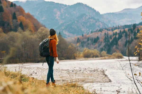Mulher viaja no outono nas montanhas perto do modelo de paisagem do rio em pleno crescimento — Fotografia de Stock