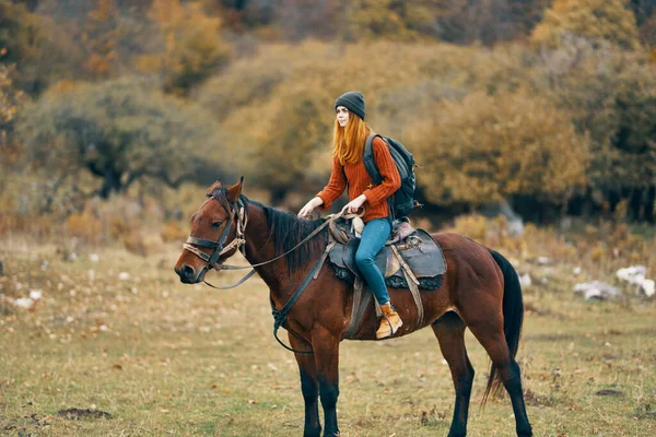 Woman hiker in the mountains riding a horse travel lifestyle — Stock Photo, Image