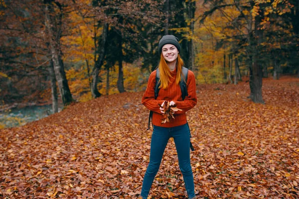 Kvinde i en sweater hat jeans 3 lov på bagsiden og naturen i baggrunden træer skov model - Stock-foto