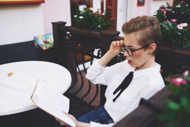 Masa başı kafe tasarımı sokak kitabı kadın öğrenci gözlük eğitimi alıyor.