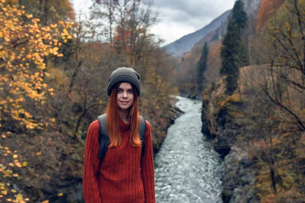 Vrouw wandelaar met rugzak in de bergen herfst bos rivier landschap — Stockfoto