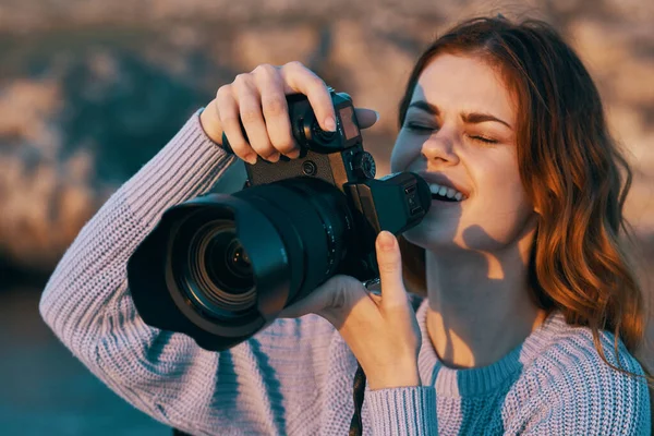 Szczęśliwa kobieta fotograf z aparatem fotograficznym w górach na łonie natury i rzeki w tle — Zdjęcie stockowe