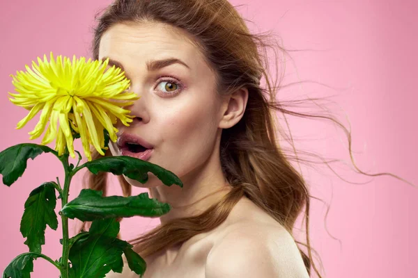 Portrait de femme aux fleurs jaunes sur fond rose Maquillage sur le visage — Photo